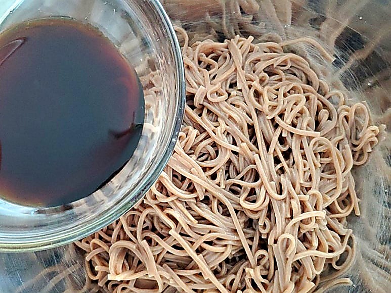 Adding soy sauce to noodles